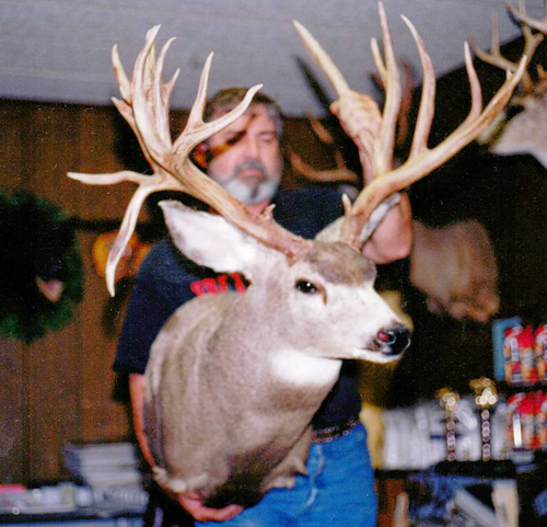 Man holding a taxidermy deer head